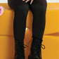 Kid wearing black cotton leggings with boots, sitting on a yellow bench – casual toddler outfit